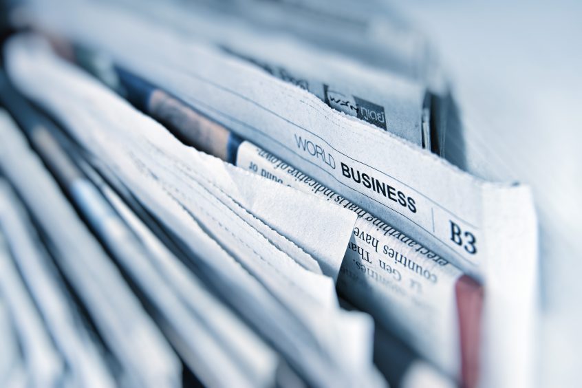 many newspapers piled together, with World Business more prominent